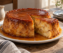 Budín de pan casero bañado en caramelo con una porción cortada